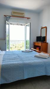 a bedroom with a blue bed with a large window at Studios Evgenia Parga in Parga