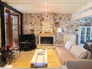 a living room with a couch and a stone wall at Dreamy Cottage in Ayiá