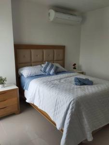 a bedroom with a large bed with a wooden headboard at Apartamento en Cartagena, Zona Urbana in Cartagena de Indias