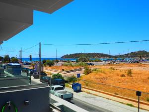 a view of a parking lot and the ocean at Golden Sand Suites in Anavyssos
