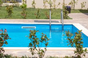 a swimming pool with blue water in a yard at Sea&Sand Apartment - Modern Sea View near Sandy Beaches in Privlaka