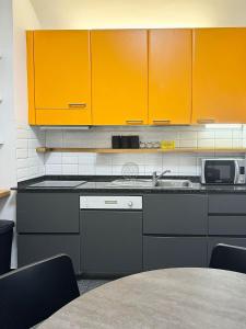 une cuisine avec des armoires orange et un évier dans l'établissement Rinascita Vatican Home, à Rome