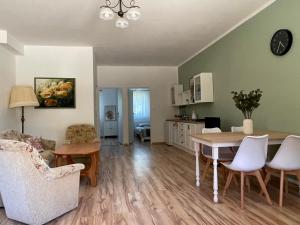a kitchen and living room with a table and chairs at Babie Lato in Mrągowo