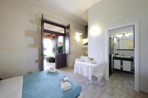 a room with a bed and a table and a bathroom at Casal Sikelio in Cassibile