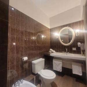 a bathroom with a toilet and a sink and a mirror at The Originals Access, Hôtel Figeac in Figeac +23 photos