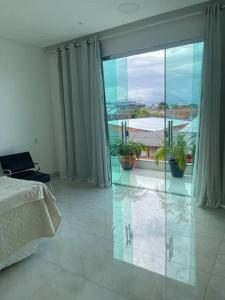 a bedroom with a bed and a large glass window at Casa Festival de Parintins 2025 com vista para o Bumbodromo in Parintins +15 photos