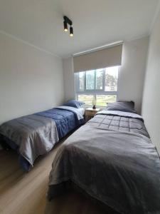 two beds in a room with a window at Depto Papudo Paseo Punta Puyai in Petorca +6 photos