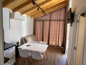 a white table and chairs in a kitchen with a window at The Bungalow's in Golem +7 photos