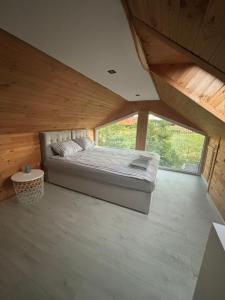 a large bed in a room with a large window at ARKANA Rydzewo in Rydzewo +15 photos