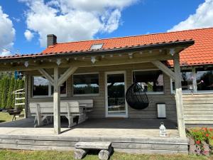 a wooden pavilion with a bench and a swing at ARKANA Rydzewo in Rydzewo