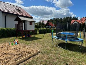 a playground with a trampoline in a yard at ARKANA Rydzewo in Rydzewo