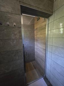 a shower with a glass door in a bathroom at Mountain Spirit Apartments near Lake Orahovica in Orahovica