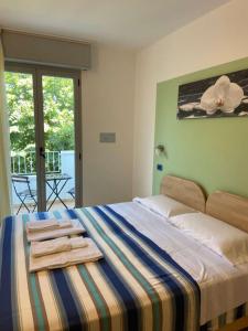 a bedroom with a bed with towels on it at Residence Cigno in Rimini