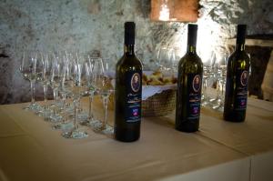 two bottles of wine sitting on a table with wine glasses at Rezidenca Sv. Peter in Malečnik