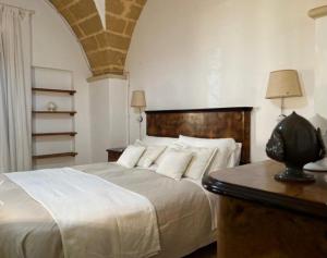 a bedroom with a bed and a table with a lamp at Masseria Sotto le Stelle Provenzani in Casalabate