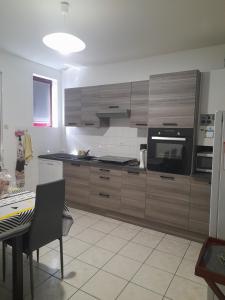 Thiel-sur-AcolinにあるMaison 14 personnes,Pal 4 kmsのキッチン(木製キャビネット、テーブル、テーブル、テーブル・シドックス・シドックス付)