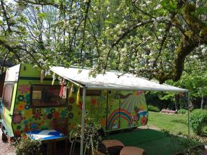a colorful food truck parked under a tree at la woodstock in Xertigny