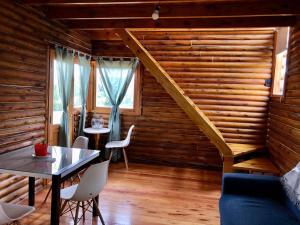 a room with a table and chairs and a staircase at Cabaña Snowflakes in Villa Yacanto
