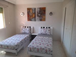 a bedroom with two beds and a window at App piscine hyvernage gueliz marrakech centre in Marrakech +15 photos