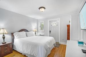a white bedroom with a large bed and a table at Villa Mulvey #2 in Saint Augustine