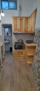 a kitchen with wooden cabinets and a stove top oven at xanthoula's house in Agios Kirykos +16 photos