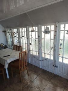 a dining room with a table and some windows at La Prietenicu in Murighiol