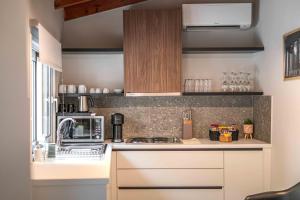 a kitchen with a stove and a microwave at Belle Athenes - Luxury Rooms at Monastiraki Railway Station in Athens