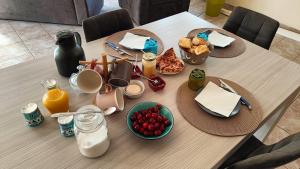 a table with breakfast foods and orange juice on it at Au BeauLieu in Beaulieu