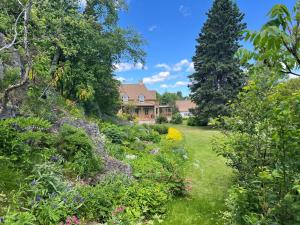 a garden with a house in the background at Maison du Havre Grand Duplex in La Malbaie