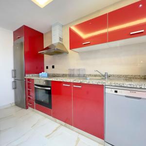 a kitchen with red cabinets and a sink at LUXURY Hilton City Center residence 5A GUEST FRIENDLY in Tangier