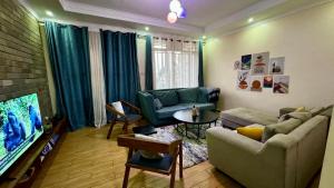 キガリにあるManna Stays, Kagaramaのソファとテレビのあるリビングルーム