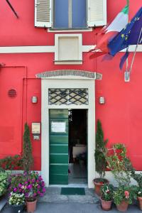 un edificio rojo con una puerta verde y flores en Affittacamere La Rosa, en Lucca