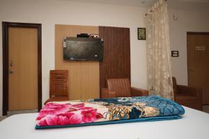 a bedroom with a bed with a television on the wall at Hotel sunshine & restaurant in Pūrnia