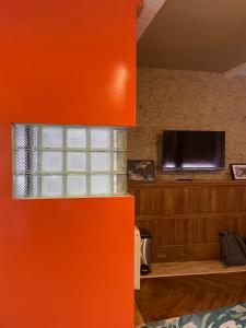 The Barbican View في بلايموث: جدار برتقالي مع نافذة وتلفزيون