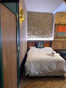 The Barbican View في بلايموث: غرفة نوم بسرير وجدار حجري