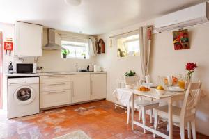 een keuken met een tafel en een wasmachine bij Studio & Garden in Lissabon