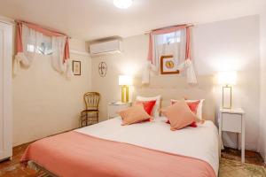 een slaapkamer met een groot wit bed met oranje kussens bij Studio & Garden in Lissabon