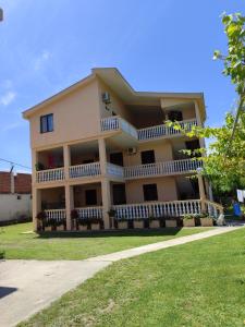 a large yellow building with a porch and balcony at Apartments Marniku in Ulcinj +27 photos