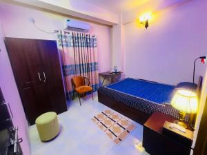 a bedroom with a bed and a desk and a chair at Cafe Green Valley in Rangpur
