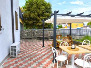 Un patio con mesa y sillas y un calentador. en SG Rooms - Casa Laura, en Peschiera del Garda