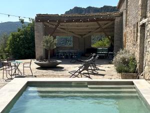 a swimming pool in a patio with a table and chairs at Masia la Oliva in Coll de Nargó