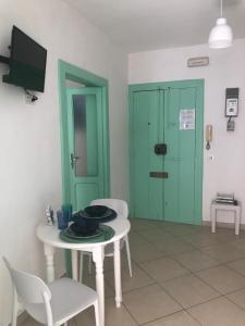 a room with a table and a green door at Mediterraneum in Bari