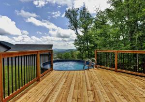 terraza de madera con piscina y valla en 32 Chemin Blanc, en Stoneham
