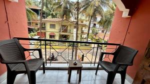 - un balcon avec deux chaises et une vue sur un bâtiment dans l'établissement Muffys 1bhk Apartment, à Baga
