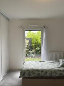 Un dormitorio con una cama y una ventana grande. en Appartement Biscarrosse, en Biscarrosse