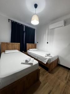 a room with two beds and a light fixture at Blue Island 1 & 2 Holiday Rentals in Karavas +23 photos