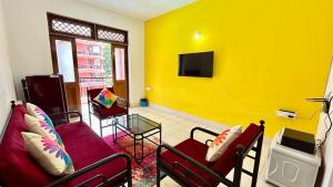 una sala de estar con 2 sofás y una pared amarilla en Muffys Holiday Apartment 2, en Baga