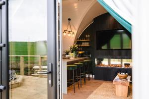 a kitchen with a bar with green stools at Kite Lodge in Little Bytham