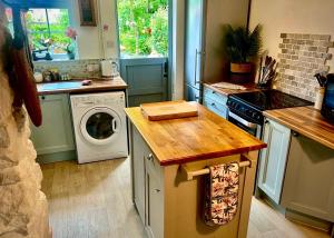 eine Küche mit Waschmaschine und Waschmaschine in der Unterkunft 18th Century Cosy Cottage with Stunning Views in Stratford-upon-Avon