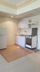 an empty kitchen with white cabinets and a stove at Al Khaleej Hotel Apartments in Amman